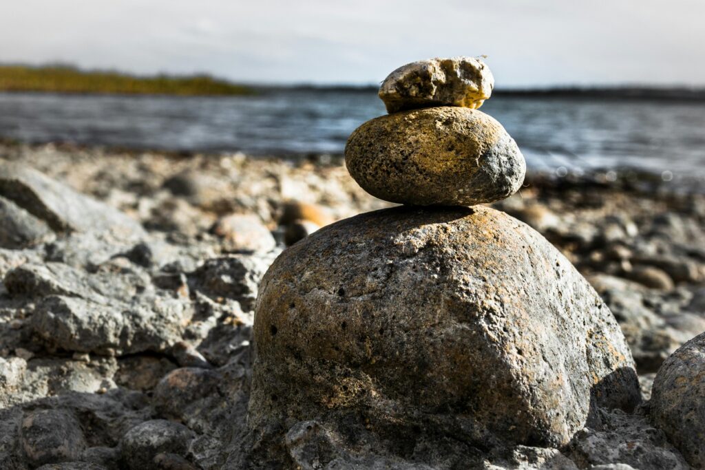 pexels photo 907911 907911 Close-up of stacked stones on a rocky lakeshore, embodying tranquility and balance.